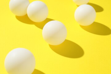 Ping pong balls on yellow background, closeup