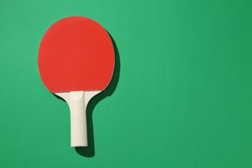 One ping pong racket on green background, top view. Space for text