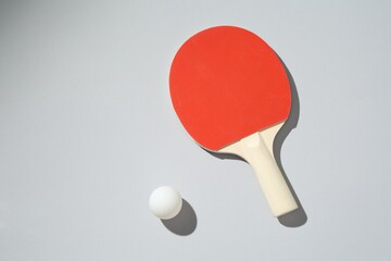 Ping pong racket and ball on light background, top view