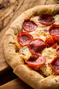 pizza peperoni en fondo de madera con luz lateral 