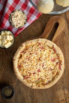 pizza  con queso en fondo de madera con luz lateral toma cenital