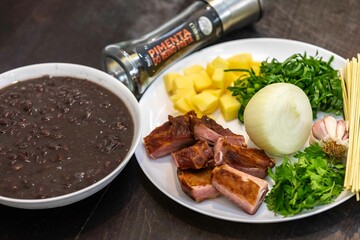 Traditional black bean soup with noodles and pork ribs, rustic Brazilian food known as sopa preta or sopa de benzedeira