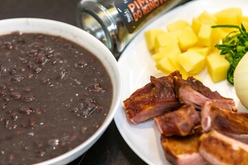 Traditional black bean soup with noodles and pork ribs, rustic Brazilian food known as sopa preta or sopa de benzedeira