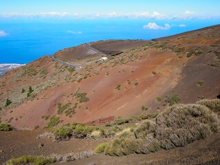 Teide National Park: black and red lava land covered with sparse greenery. Volcanic landscape of...