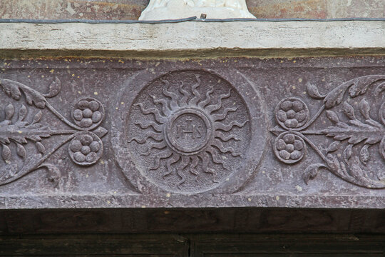 il monogramma di Cristo; architrave del portale della chiesa di Santa Maria della Neve a Pisogne (Brescia)