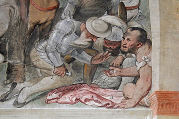 i soldati si giocano le vesti di Gesù; particolare dell'affresco della crocefissione del Romanino nella  chiesa di Santa Maria della Neve a Pisogne (Brescia)