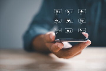 Digital interaction at home man types on smartphone, exploring live chat and social network concepts. Chat box icons pop up, symbolizing modern communication. Social media marketing technology