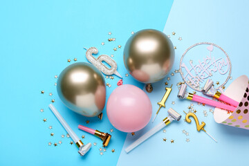 Flat lay composition with party hat and balloons on light blue background