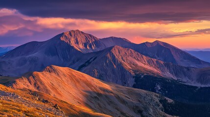 Naklejka premium The mountains are covered in snow and the sun is setting. The sky is a mix of orange and pink hues