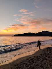 Naklejka premium silhouette of girls walking on the sea beach at sunset