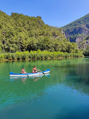 two people are sailing in a canoe on the river