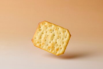 cracker levitating on beige background
