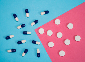 Various pills dispersed across light blue background.