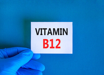 Vitamin B12 symbol. Concept words Vitamin B12 on beautiful white card. Doctor's hand in blue medical glove. Beautiful blue background. Medical healthy lifestyle Vitamin B12 concept.