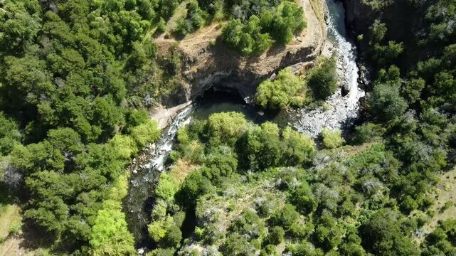 R&iacute;o Coyhaique brilla bajo el sol mientras se abre paso entre &aacute;rboles y pendientes cordilleranas.