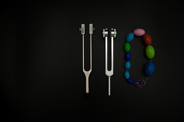 tuning fork C 128 on a black background with gradation and otorhinoscope and neurological hammer