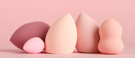 Many makeup sponges on pink background