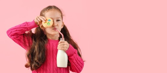 Funny little girl with tasty cookie and bottle of milk on pink background with space for text