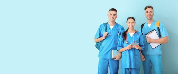 Group of medical students on light blue background with space for text