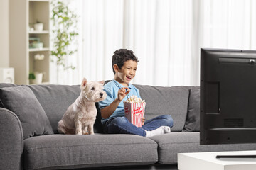 Fototapeta na wymiar Kid eating popcorn and watching tv