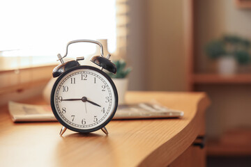 Black alarm clock on table in room. Closeup