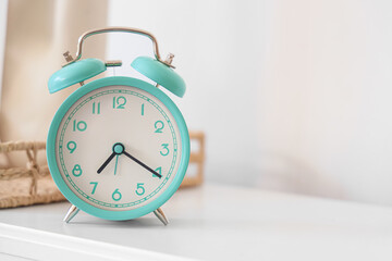 Turquoise alarm clock with decor on shelf in room. Closeup