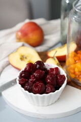 Tasty cherries, apples and sea buckthorn berries on light grey table, closeup