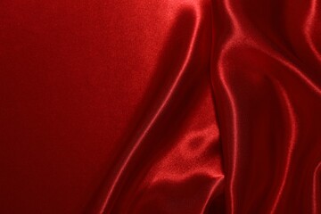 Red crumpled silk fabric as background, top view
