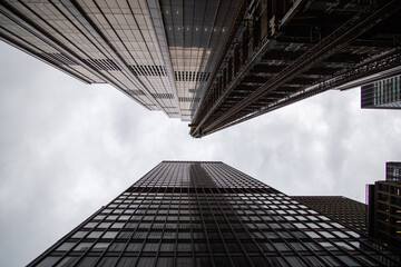 Symmetrical modern building, looking up sky, NYC