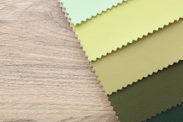Fototapeta premium Samples of different fabrics on wooden table, top view. Space for text