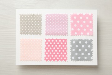 Samples of fabrics with polka dot pattern on light wooden table, top view