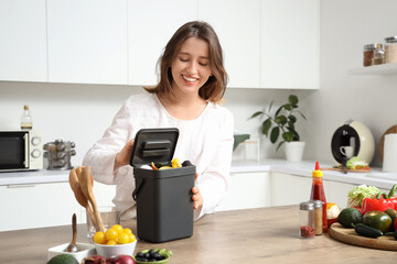 Young woman with compost bin in kitchen