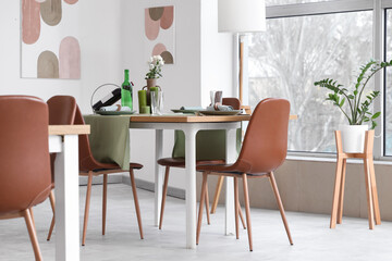 Interior of restaurant with table, flowers and paintings