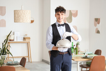Male waiter with cloche in restaurant