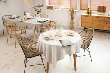 Interior of light restaurant with tables and drawers