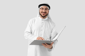 Arab businessman in eyeglasses with folder on light background