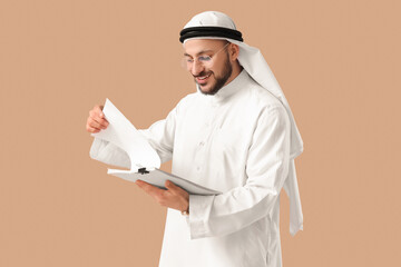 Arab businessman with papers on beige background