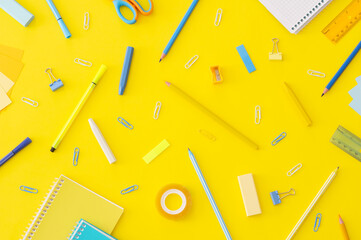 Back to school concept, school supplies and accessories on yellow background, notebook, pencils, paperclip, duster, flat lay copy space