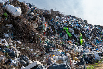 Extensive Landfill Site Showing Accumulated Waste Materials, Plastic Refuse, Organic Matter, and Discarded Items Against Sky