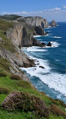 Fototapeta premium Coastal Cliffs and Blue Sea: Rugged Rocks, Green Grass, and Ocean Waves Under a Sunny Sky