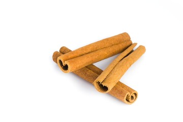 Isolated cinnamon bark pieces on white, emphasizing their rugged surfaces and deep brown shades.
