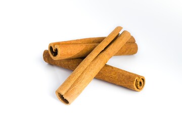 Assorted cinnamon bark pieces arranged on white, focusing on their fibrous texture and earthy hues.