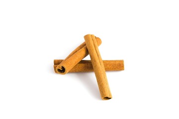 Scattered cinnamon bark pieces on a white surface, capturing their rustic texture and deep brown shades.
