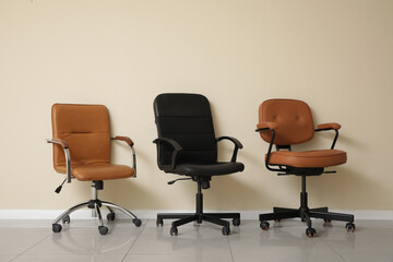 Office leather chairs near white wall in room