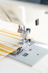 sewing machine with a cloth under a steel needle. manufacture of clothing. a household or industrial sewing machine. tailor, couturier. work on sewing designer clothes.