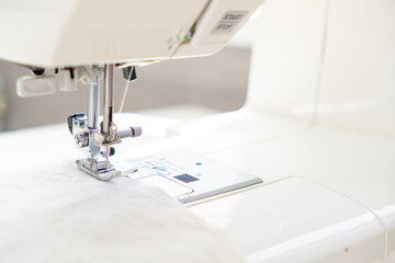 sewing machine with a cloth under a steel needle. manufacture of clothing. a household or industrial sewing machine. tailor, couturier. work on sewing designer clothes.