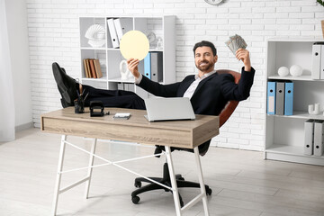 Happy businessman with bitcoin and dollar banknotes at table in office