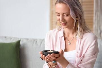 Woman with burning candle at home