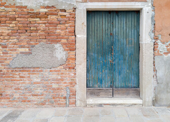 Old blue wooden door in brick wall