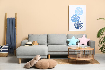 Interior of stylish living room with grey sofa, wooden coffee table and summer decor